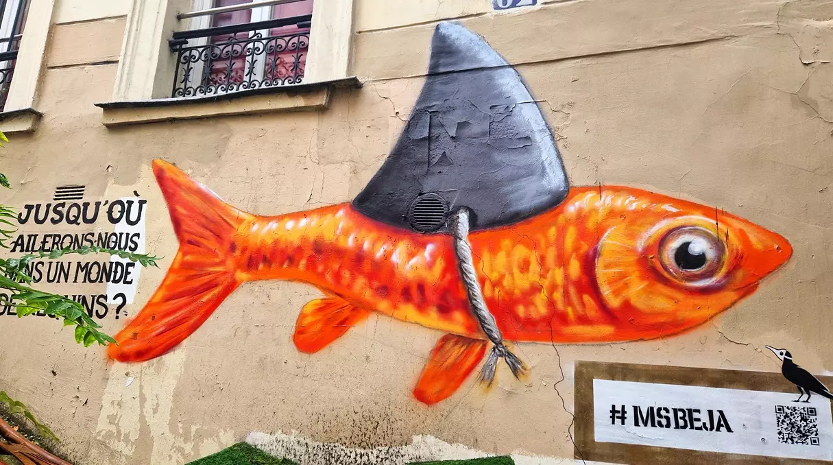 Street art d'un poisson rouge portant un aileron de requin, peint par MSBEJA sur une façade de Belleville