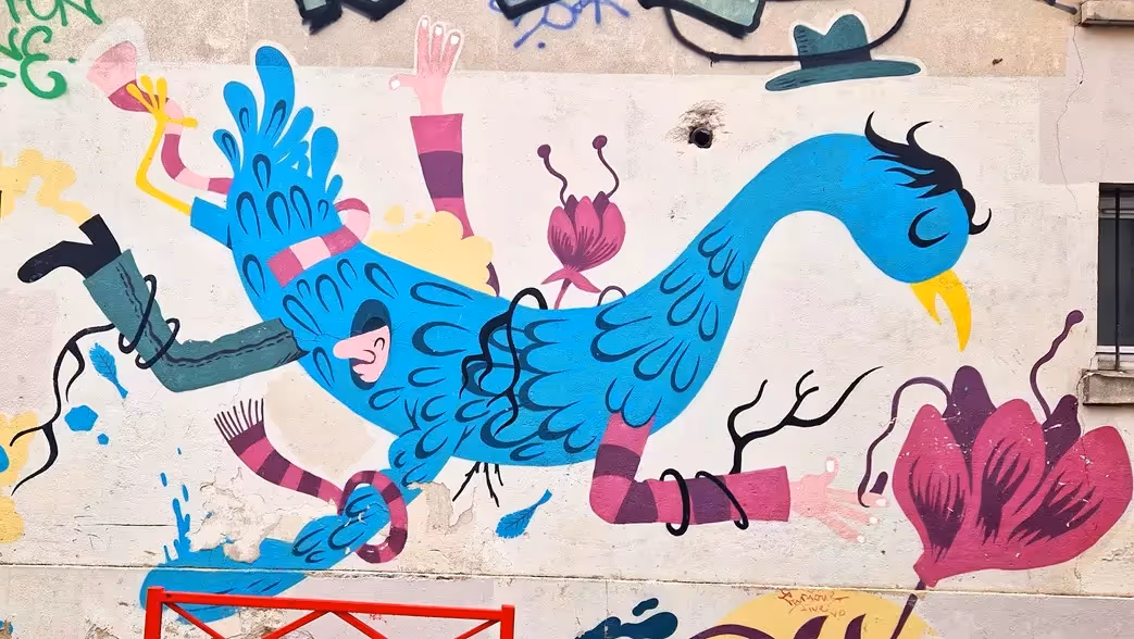 Fresque colorée de Mr Pee, grand oiseau bleu et personnages fantaisistes sur un mur
